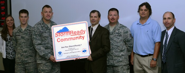 Joint Base Charleston was recently recognized as a Storm Ready community by the National Weather Service. The Storm Ready status is given to communities that are prepared for severe weather, educate their people and develop a good working relationship with NWS. From left to right are Sarah Winberry, 628th Civil Engineer Squadron installation emergency manager,  Senior Airman Ross Kreikemeier, 628th CES Emergency Management flight, and the team lead for the Storm Ready program, Col. Richard McComb, Joint Base Charleston commander, Ronald Morales, Jr., warning coordination meteorologist at the NWS office, Charleston, S.C., Tech. Sgt. Gerald McPherson, 437th Operations Support Squadron Weather Flight, Brian Dillo, 628th ABW Command Post, and Mike Emlaw, Meteorologist at the NWS office in Charleston, S.C. (U.S. Air Force/Tech Sgt. Chrissy Best) 