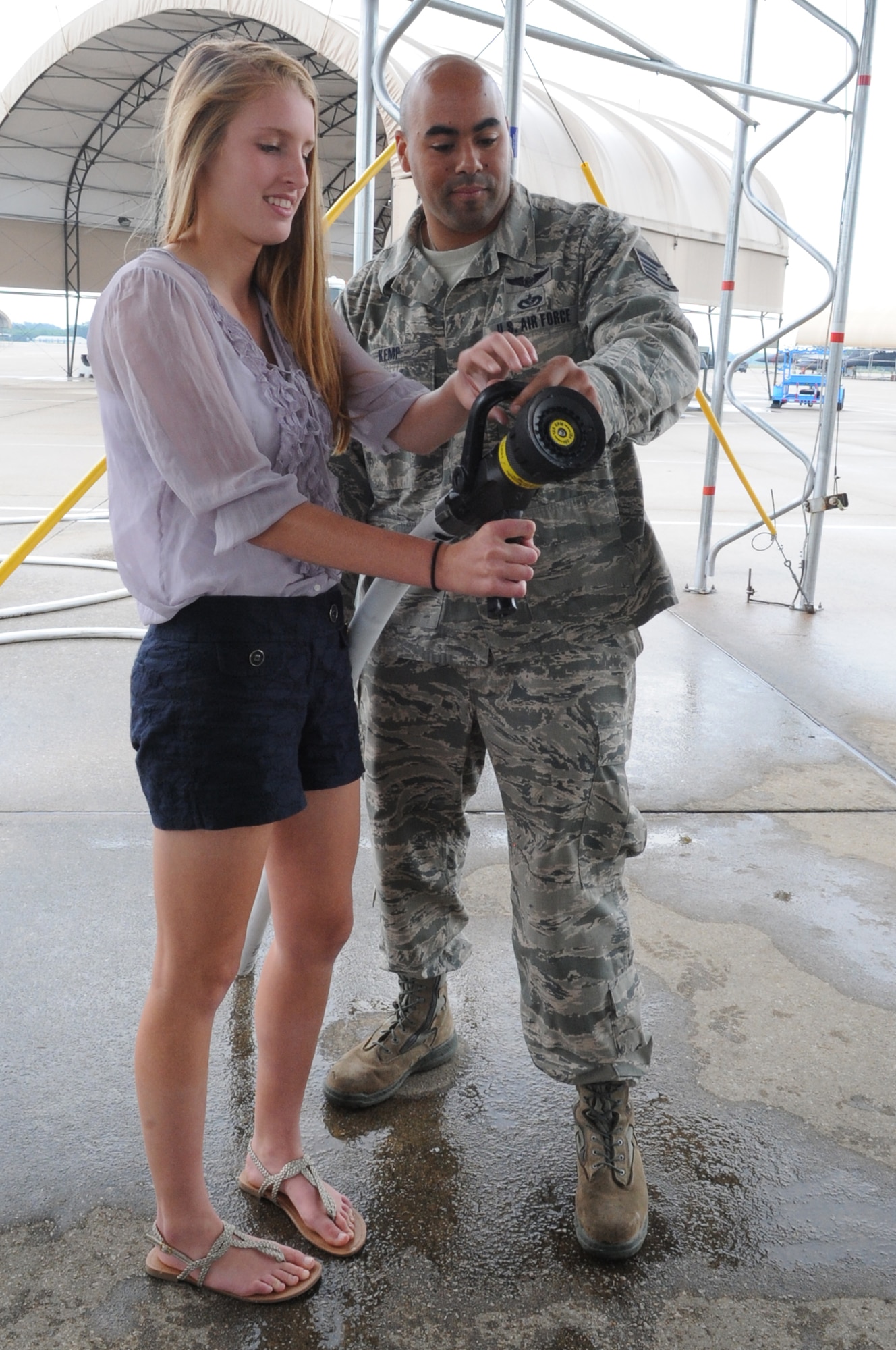 U.S. Air Force Staff Sgt. Rodger Kemp shows Brooke Doherty, 17,  how to use a fire hose during her father’s “fini flight” on Seymour Johnson Air Force Base, N.C., May 23, 2012. Brooke is the daughter of U.S. Air Force Col. Patrick Doherty, the current 4th Fighter Wing commander who will relinquish command of the 4th FW to Col. Jeannie Leavitt in a change-of-command ceremony, June 1. Kemp, 4th Civil Engineer Squadron fire emergency services flight firefighter, is from Chicago. (U.S. Air Force photo/Airman 1st Class Aubrey Robinson/Released)
