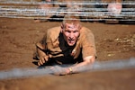 Jeffrey Greenwood, lieutenant colonel and commander of the 323rd Training Squadron, endures the low-crawl event during the 15-obstacle Spartan Sprint Race Saturday in Burnet, Texas. (U.S. Air Force photo/Nicole Greenwood)
