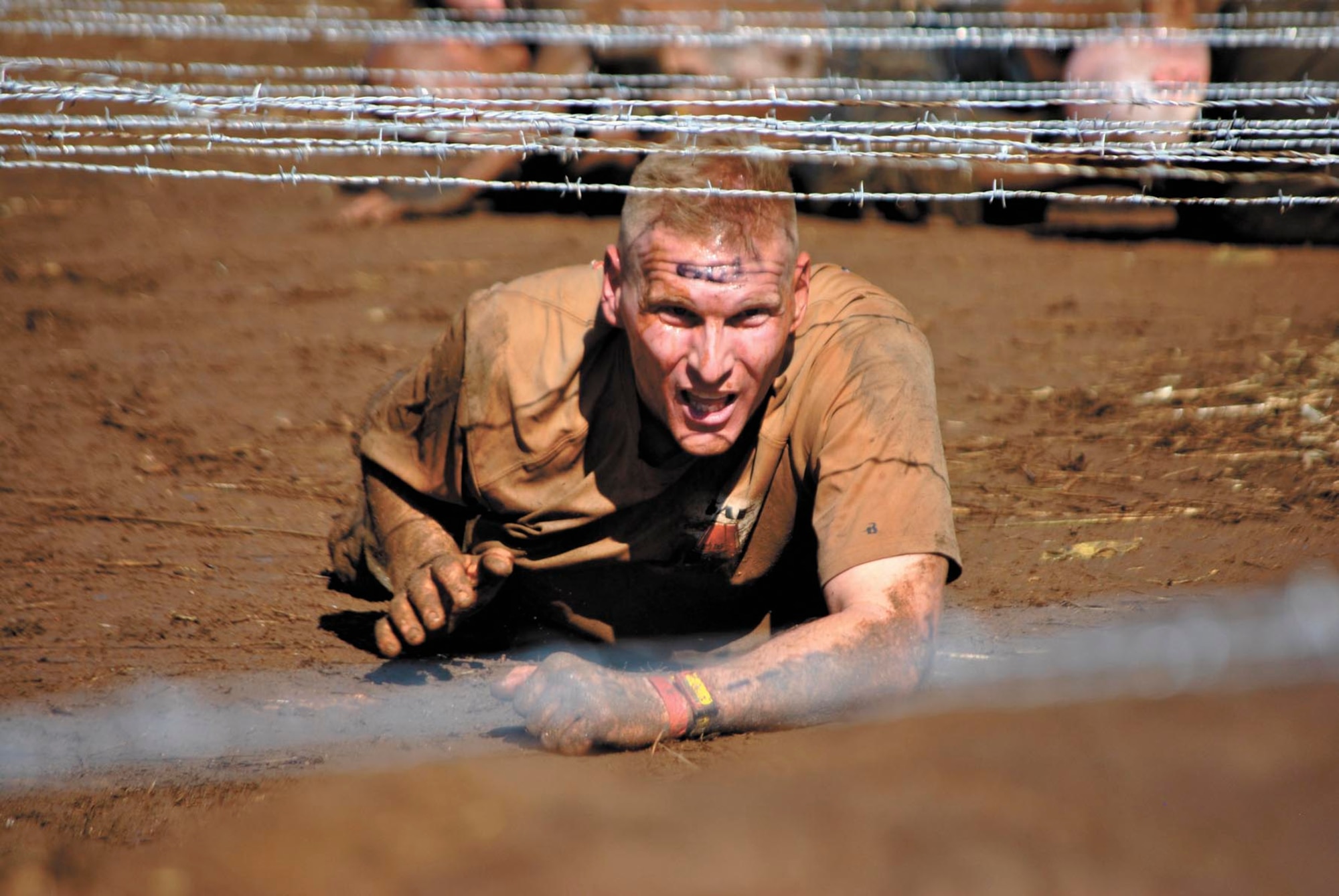 Jeffrey Greenwood, lieutenant colonel and commander of the 323rd Training Squadron, endures the low-crawl event during the 15-obstacle Spartan Sprint Race Saturday in Burnet, Texas. (U.S. Air Force photo/Nicole Greenwood)
