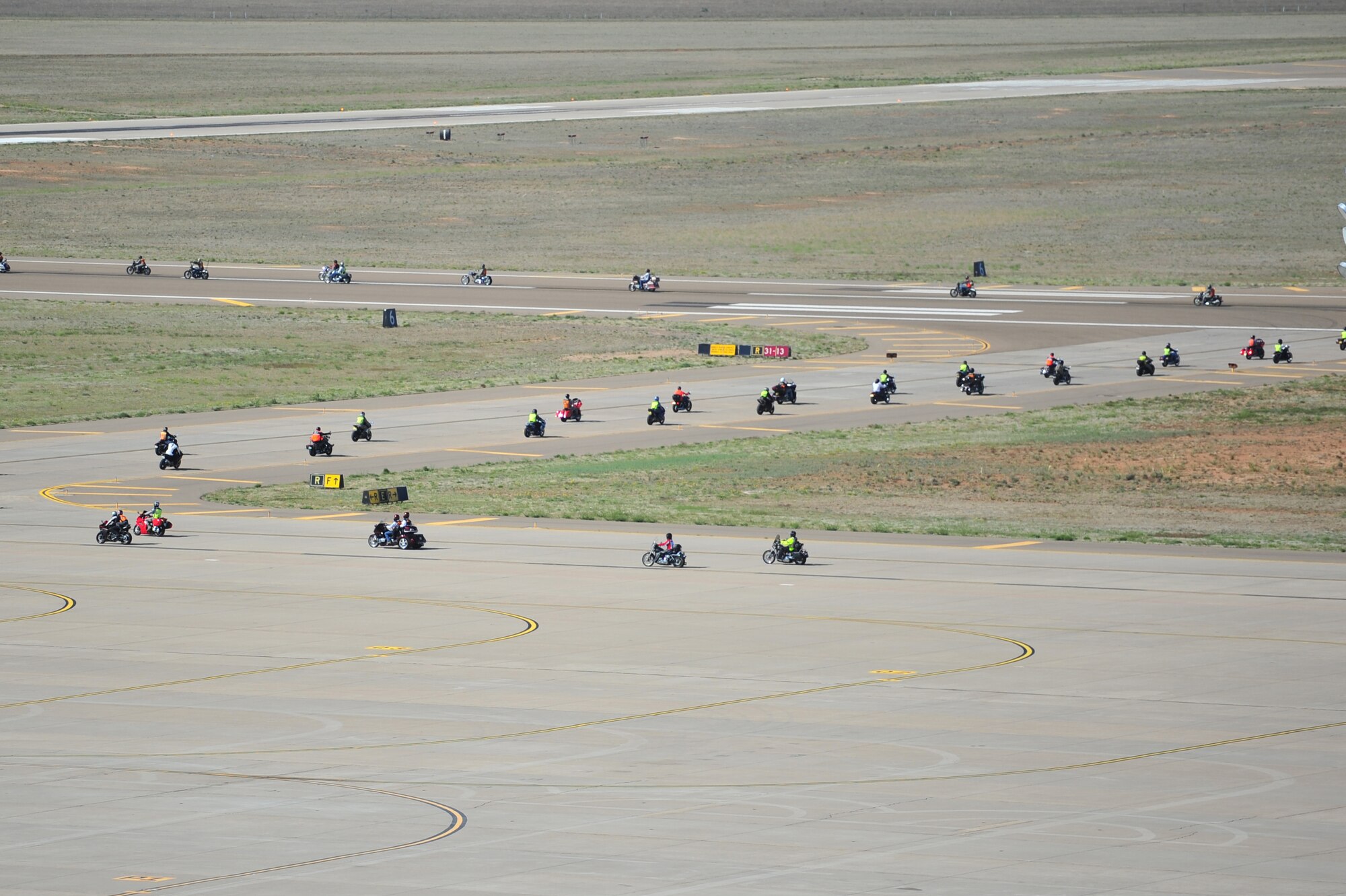Air Commandos ride their motorcycles onto the flightline during safety day at Cannon Air Force Base, N.M., May 18, 2012. More than 30 motorcycles zoomed across the flightline before concluding the ride in front of the wing headquarters building. (U.S. Air Force photo by Airman 1st Class Eboni Reece)  