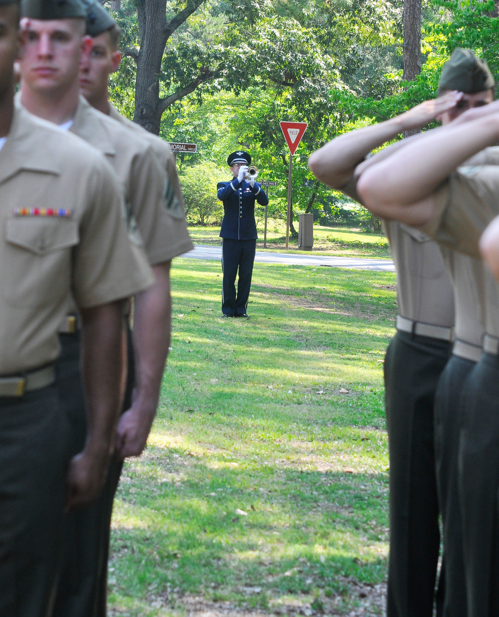 Airman 1st Class Mark Oates plays Taps during the Camellia Garden Memorial Service Thursday. (U. S. Air Force photo by Sue Sapp)