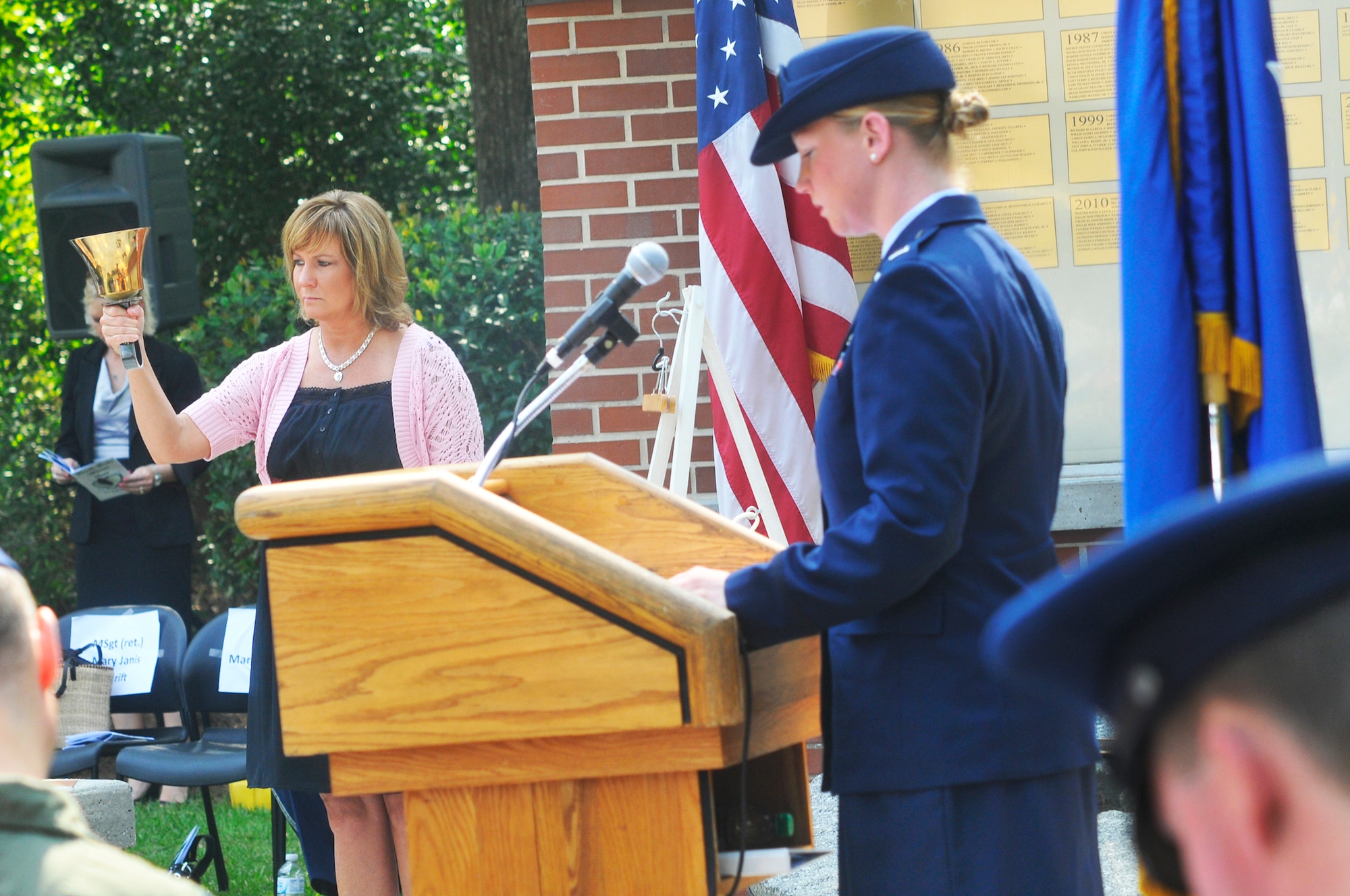 Margaret Scheer chimes a bell as 1st Lt. Yvonne Johnston reads the names of the deceased members of Team Robins.(U. S. Air Force photo by Sue Sapp)