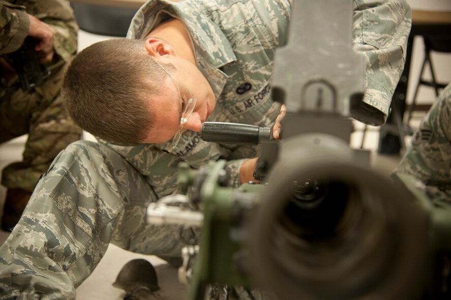 U.S. Air Force Staff Sgt. Jancey Alamos, 820th Combat Operations Squadron combat arms instructor, demonstrates the parts of an M2 machine gun at Moody Air Force Base, Ga., May 23, 2012. Alamos instructed weapons familiarization to Airmen from six other bases scheduled to deploy with the 824th Base Defense Squadron. (U.S. Air Force photo by Airman 1st Class Paul Francis/Released)
