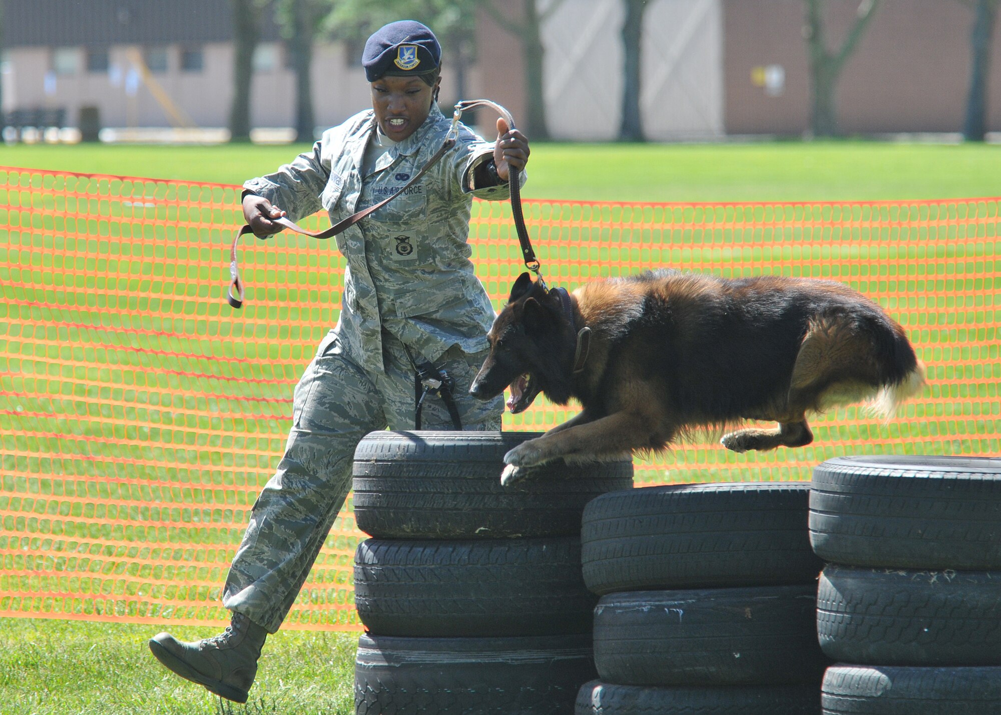 KIRTLAND AFB, N.M. -- Senior Airman Khadijah Muhummed, 377th Security Forces Squadron, navigates “Igor” over an obstacle May 19 at the police dog trial during National Police Week. The dogs were judged on obedience and agility. (Photo by Todd Berenger)