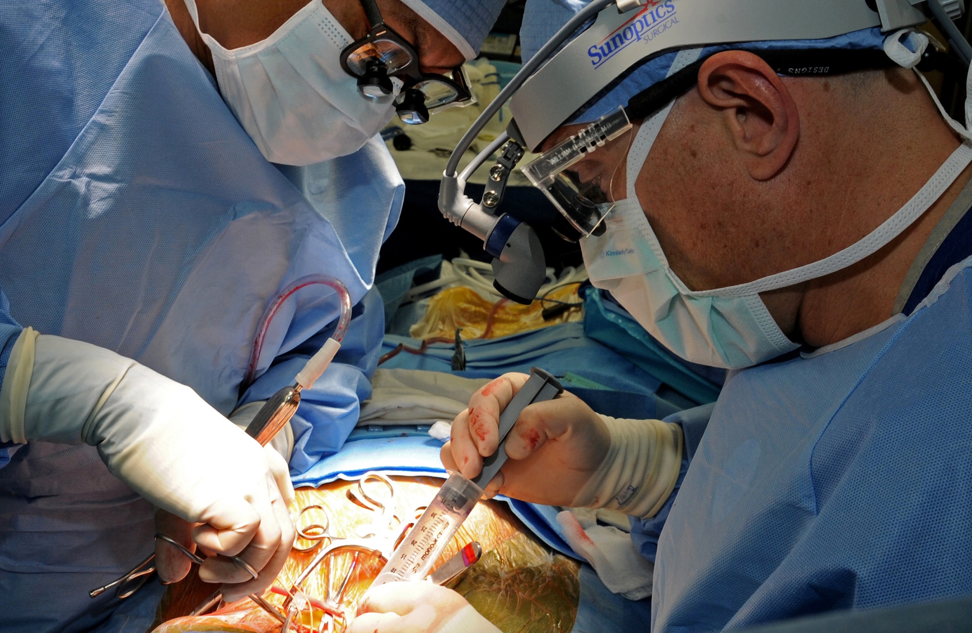 Physician assistant William Gadea assists Col. (Dr.) Darrin Clouse, 60th Surgical Operations Squadron vascular surgeon, during a carotid endarterectomy surgery May 23 at David Grant USAF Medical Center. (U.S. Air Force photo/ Staff Sgt. Liliana Moreno)
