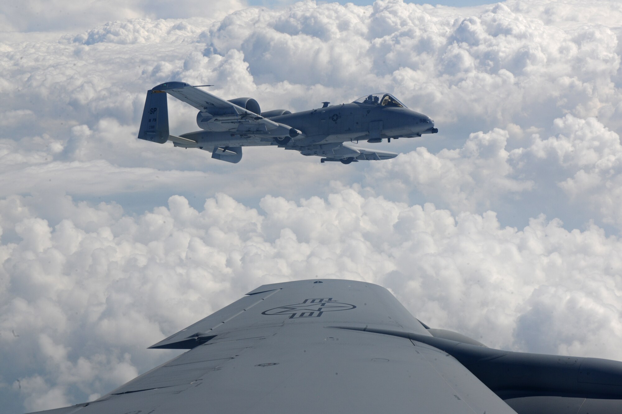 SPANGDAHLEM AIR BASE, Germany – An A-10 Thunderbolt II from the 81st Fighter Squadron flies beside a 351st Air Refueling Squadron KC-135 Stratotanker out of Royal Air Force Mildenhall, England during an orientation flight for 25 52nd Fighter Wing Airmen and spouses here May 23. The Airmen and spouses flew on a 351st ARS KC-135 stationed out of RAF Mildenhall during an in-flight refueling of 81st and 480th Fighter Squadron aircraft from Spangdahlem AB. The 351st ARS and 52nd FW aircrew train together to enhance their interoperability to perform in-flight refueling missions. (U.S. Air Force photo by Airman 1st Class Matthew B. Fredericks/Released)