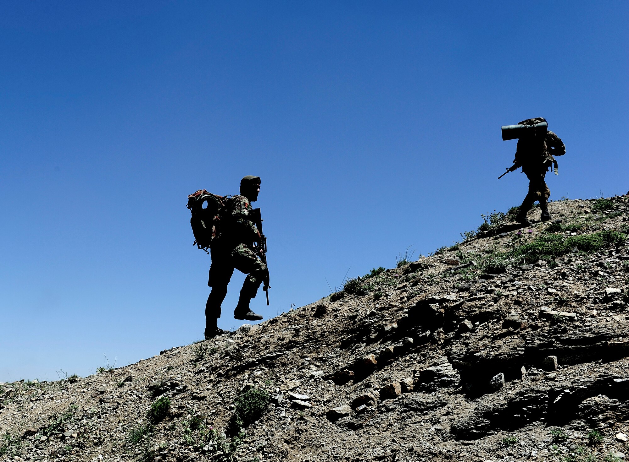 An Air Force Security Forces member  from the 439th Air Expeditionary Advisor Squadron climbs a mountain with a member of the Afghan Air Force during a mounted and dismounted patrol outside of Kabul, Afghanistan, May 21, 2012. Seven members of the 439th AEAS trekked up the mountain with the AAF security forces to give advice and guidance throughout the mission. (U.S. Air Force photo/Staff Sgt. Clay Lancaster)