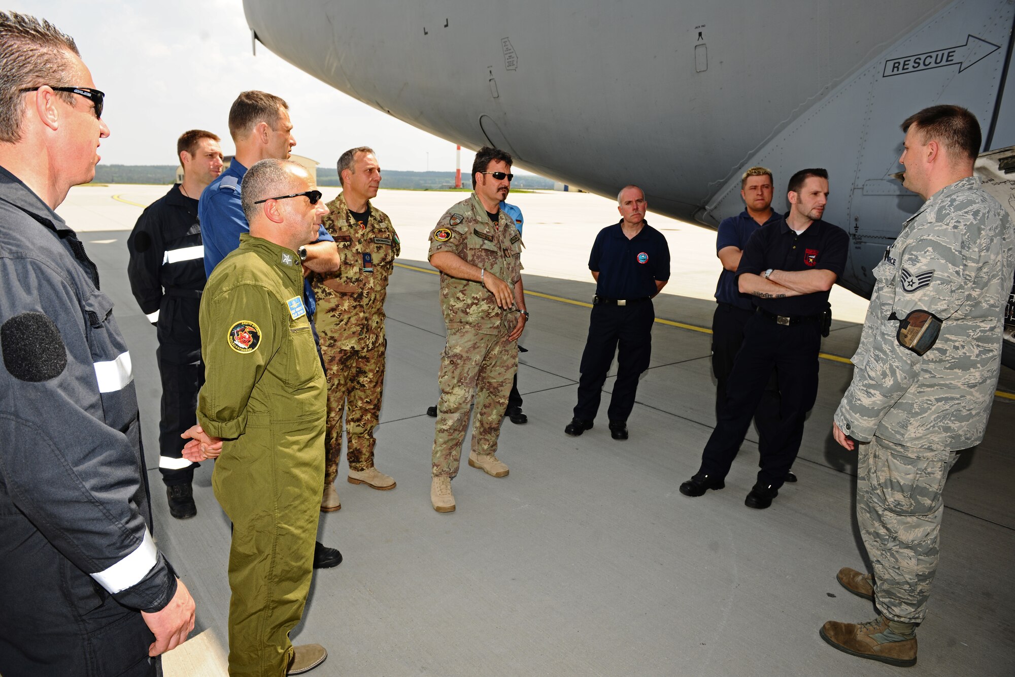 SPANGDAHLEM AIR BASE, Germany – U.S. Air Force Staff Sgt. Tyler Spencer, right, 726th Air Mobility Squadron C-17 Globemaster III crew chief, talks about the entrances to a C-17 with NATO firefighters during emergency entrance and egress training on Ramp 5 here May 22. NATO firefighters from Germany, Italy, Belgium and the Netherlands participated in the training to enable them to teach firefighters at their base to safely and quickly enter and exit a C-17 during emergency situations. (U.S. Air Force photo by Airman 1st Class Matthew B. Fredericks/Released)