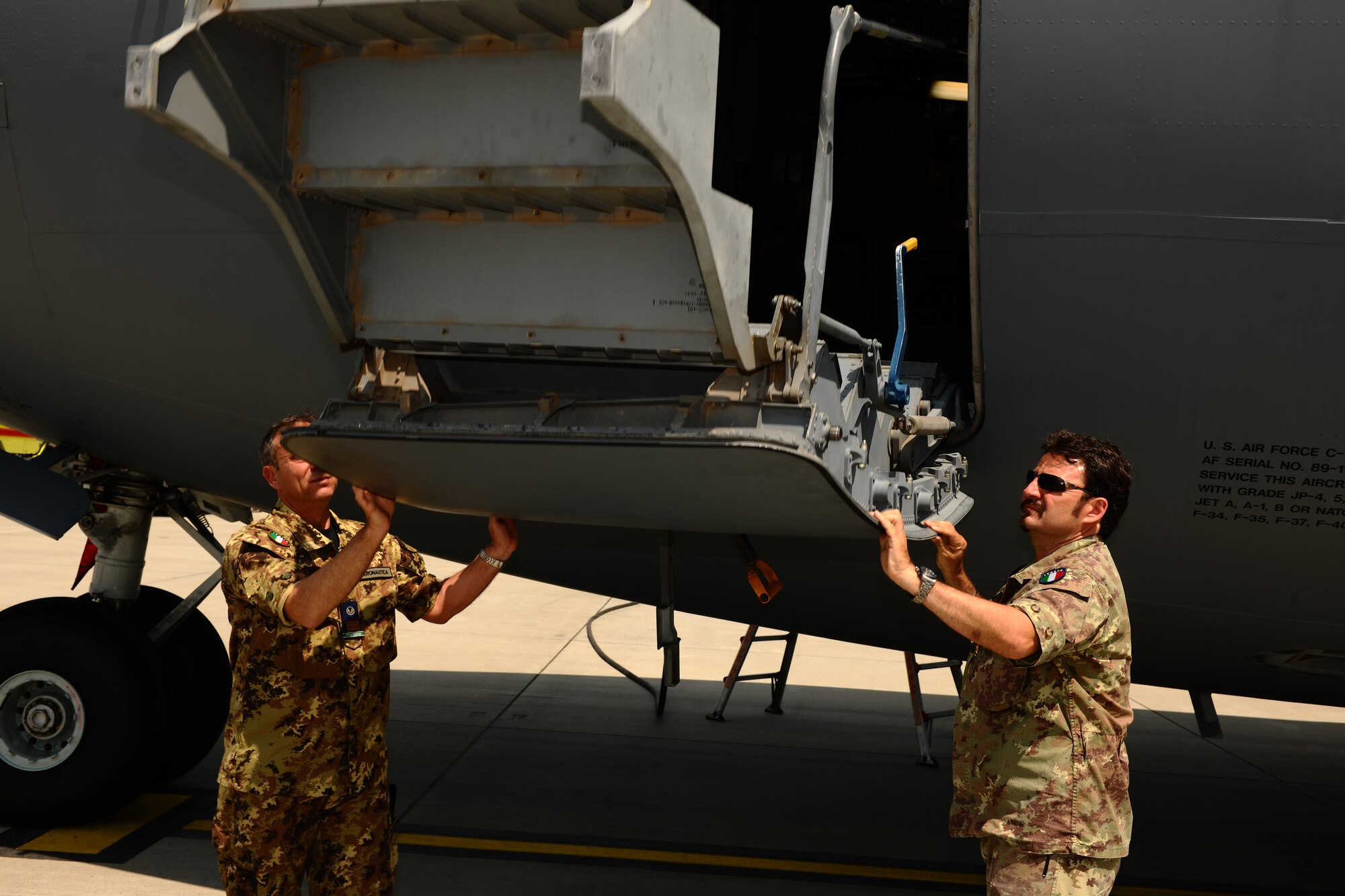 SPANGDAHLEM AIR BASE, Germany – Italian air force Warrant Officers 4 Francesco Martina, left, and Michele Saracino, NATO firefighters, lower stairs of a C-17 Globemaster III during emergency entrance and egress training on Ramp 5 here May 22. NATO firefighters from Germany, Italy, Belgium and the Netherlands participated in the training to enable the attendees to teach firefighters at their bases to safely and quickly enter and exit a C-17 during emergency situations. (U.S. Air Force photo by Airman 1st Class Matthew B. Fredericks/Released)