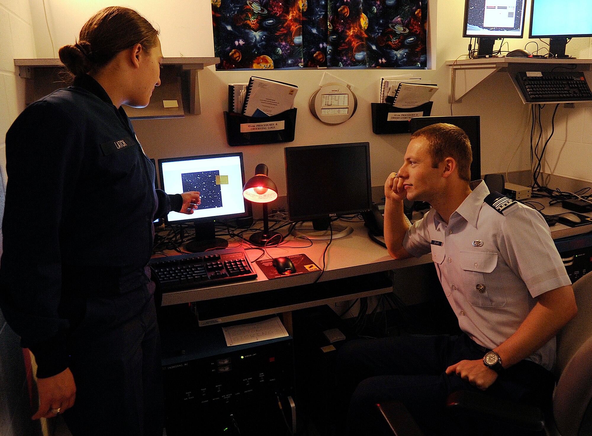 Cadets 1st Class Samantha Latch and Gordon Spahr discuss observation data on Wasp-12b, an extra-solar planet more than 870 light-years away in the constellation Auriga, during research at the Air Force Academy April 12, 2012. Techniques used to gather data on Wasp-12b can also be applied to satellites orbiting the Earth, giving the Air Force greater space situational awareness. Latch will attend pilot training after graduation, while Spahr will study for a master's degree at the Air Force Institute of Technology. (U.S. Air Force photo/Sarah Chambers)