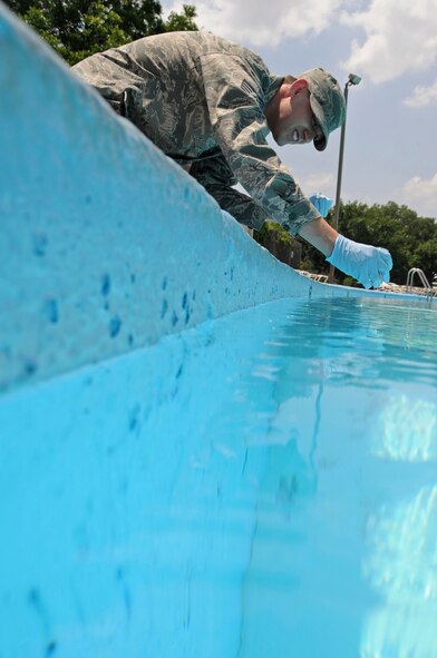 Staff Sgt. Mario Falcone, 2nd Aerospace Medicine Squadron, takes a sample from a pool to test for bacteria and chemical levels on Barksdale Air Force Base, La., May 23. Pools on base are tested once a month by bioenvironmental Airmen  and every two hours by life guards to ensure the pool is safe to swim in. (U.S. Air Force photo/Airman 1st Class Micaiah Anthony)(RELEASED)