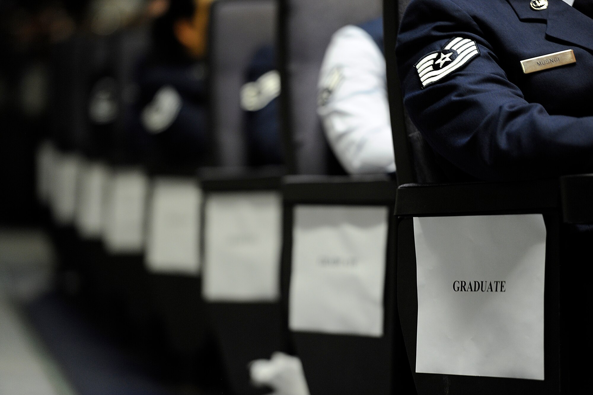 U.S. Air Force Airmen wait to receive their Community College of the Air Force degrees during a mass CCAF graduation ceremony at the Keystone Theater on Kadena Air Base, Japan, May 24, 2012. Nearly 250 Airmen from the 18th Wing and partner units on Kadena graduated with CCAF degrees this year, contributing to one of the largest graduating classes since the college's creation roughly 40 years ago. (U.S. Air Force photo/Airman 1st Class Maeson L. Elleman)