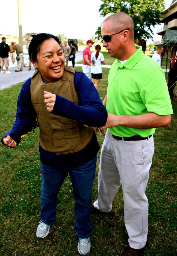 Staff Sgt. William Joyner, linguist manager, Alpha Company 2nd Radio Battalion, tightens a flak jacket on his wife, Kimberly Joyner at 2nd Radio Battalion’s Jane Wayne Day, aboard Marine Corps Base Camp Lejeune, N.C., May 19, 2012. Jane Wayne day is an annual event held by 2nd Radio Bn. to give spouses an opportunity to participate in activities such as firing weapons and Marine Corps Martial Arts. (U.S. Marine Corps photo by Cpl. Daniel A. Wulz)
