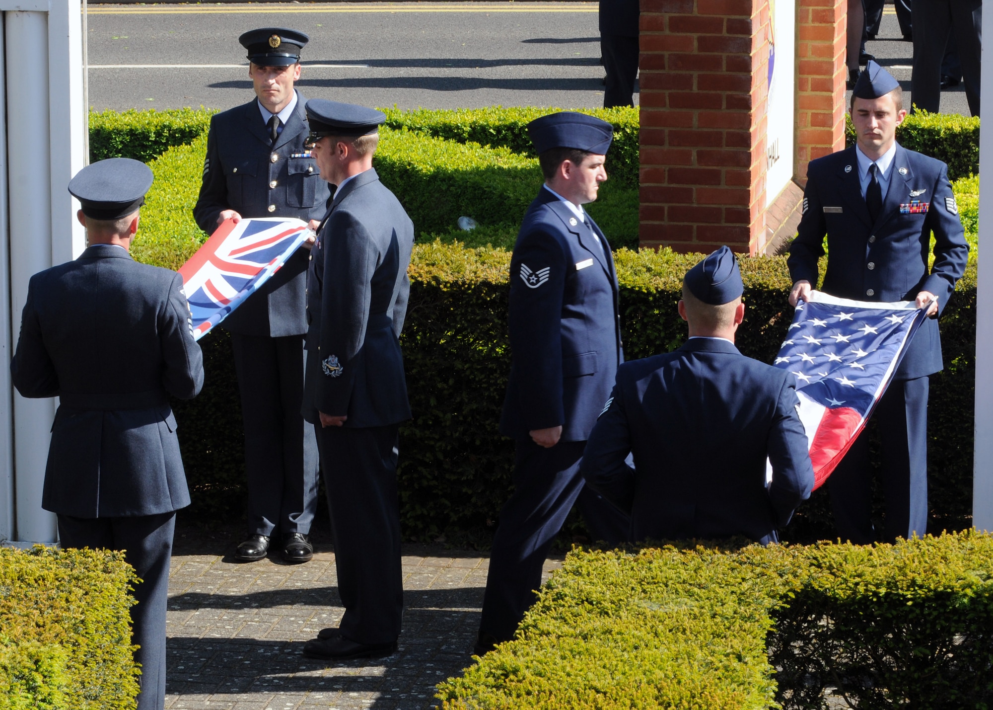 RAF MILDENHALL, England – Team Mildenhall Airmen from the 488th Intelligence Squadron and 95th Reconnaissance Squadron and British airmen from the 51 Squadron, Royal Air Force Waddington, participate in a retreat ceremony here, May 25, 2012. The 51 Sq. and the 488th IS are sister squadrons and routinely train together. Retreat signals the end of the duty day, while also paying respect to the flag. (U.S. Air Force photo/Master Sgt. Kevin Wallace)  