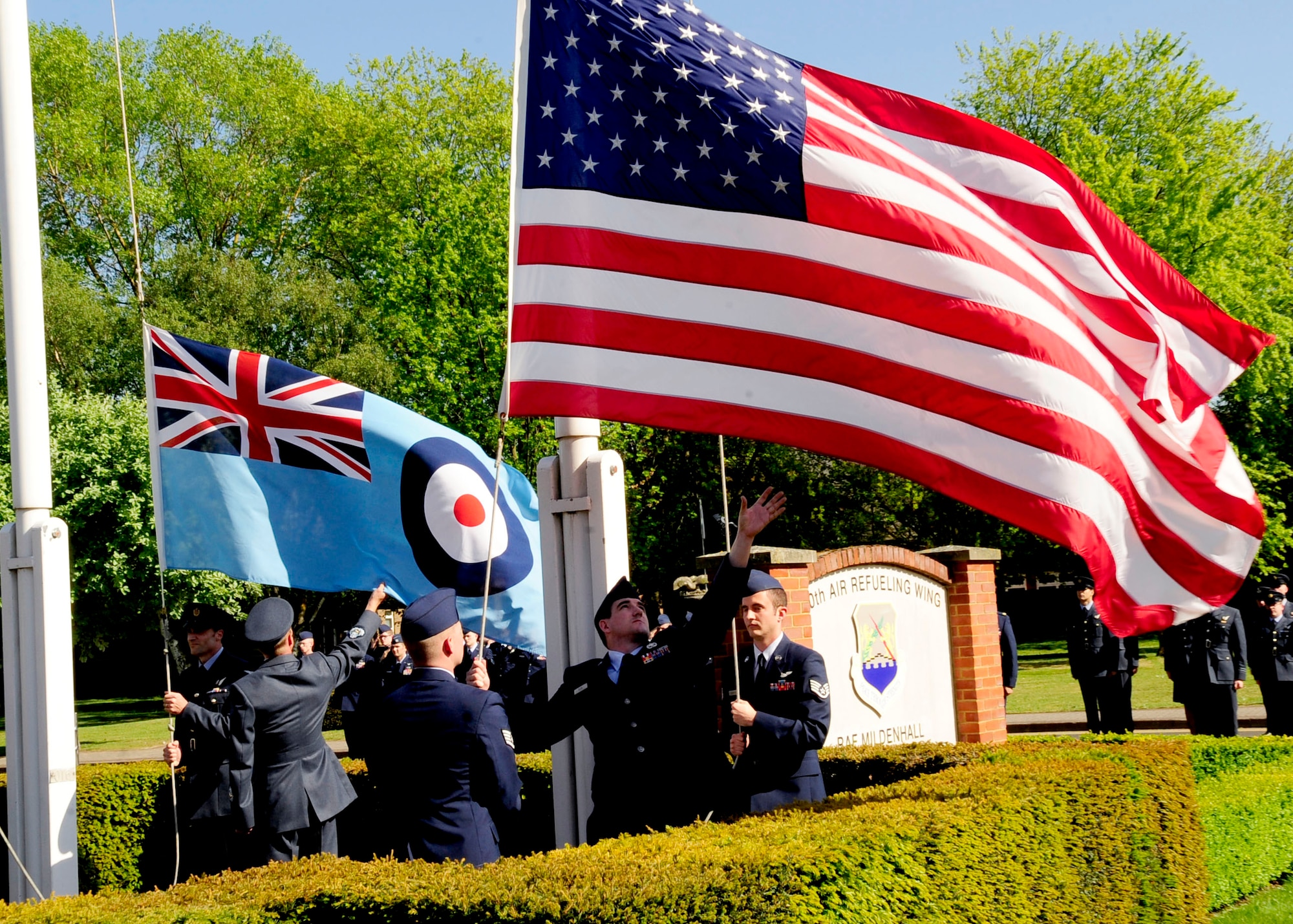 RAF MILDENHALL, England – Team Mildenhall Airmen from the 488th Intelligence Squadron and British airmen from the 51 Squadron, Royal Air Force Waddington, reach to collect both the American flag and the Royal Air Force Ensign in a retreat ceremony here, May 25, 2012. . During retreat the flag is lowered and taken off the pole and a detail of Airmen give it a distinct fold. (U.S. Air Force photo/Senior Airman Ethan Morgan)  