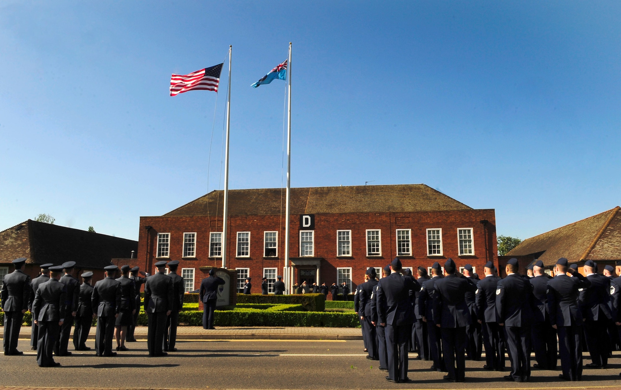 RAF MILDENHALL, England – Team Mildenhall Airmen from the 488th Intelligence Squadron and 95th Reconnaissance Squadron and British airmen from the 51 Squadron, Royal Air Force Waddington, salute as both the American flag and the Royal Air Force Ensign are prepared to be lowered in a retreat ceremony here, May 25, 2012. Retreat signals the end of the duty day, while also paying respect to the flag. (U.S. Air Force photo/Senior Airman Ethan Morgan)  