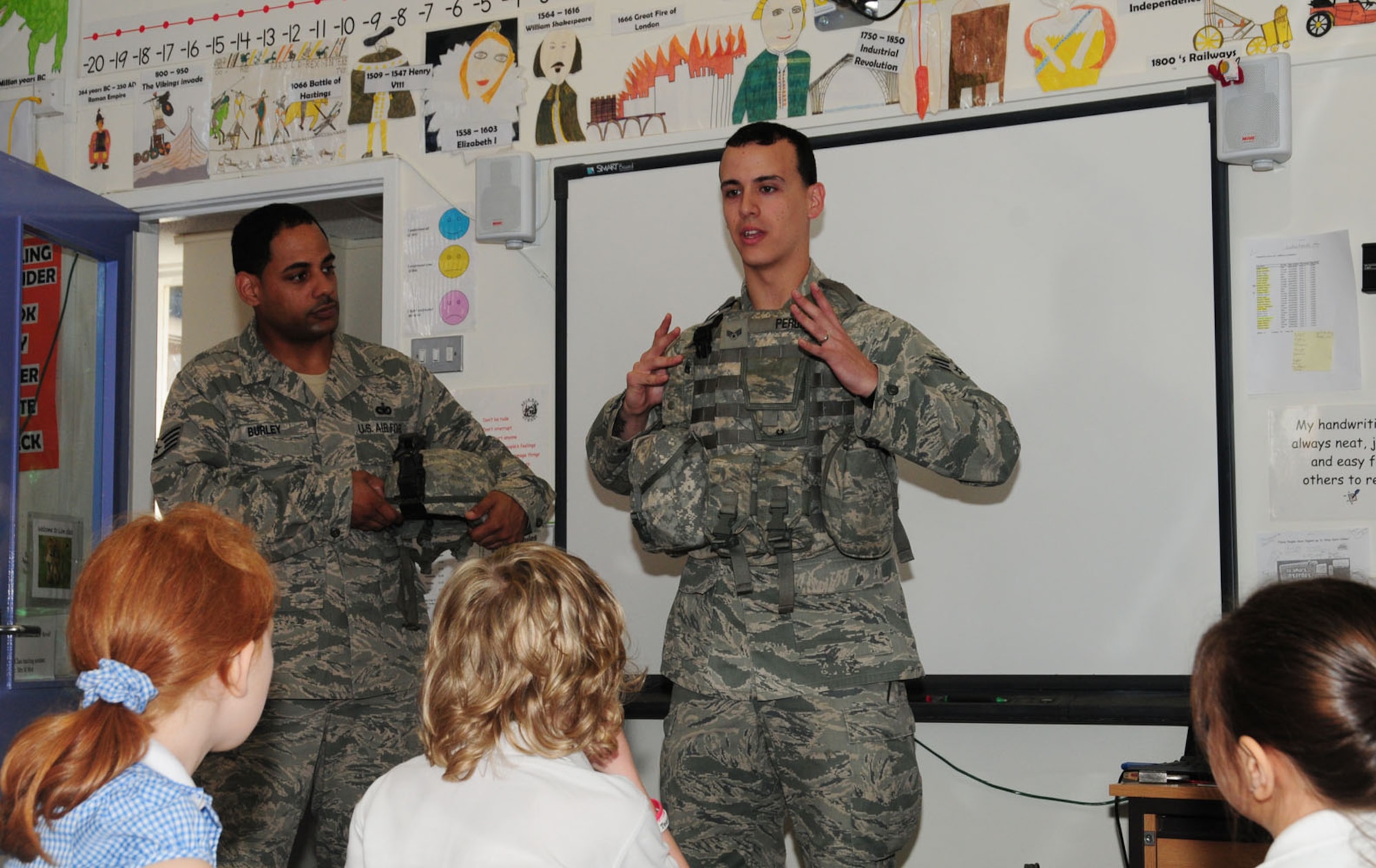 BECK ROW, England – Staff Sgt. Theodore Burley and Senior Airman Jerimiah Perou, both 100th Security Forces Squadron, talk to children at Beck Row Primary School near RAF Mildenhall, May 25, 2012, talk to children about their job and what they do to protect people. Seven 100th SFS members visited the school and showed the children various equipment including a Kevlar helmet, handcuffs, night-vision goggles and bullet-proof plates for protective vests. (U.S. Air Force photo/Karen Abeyasekere)