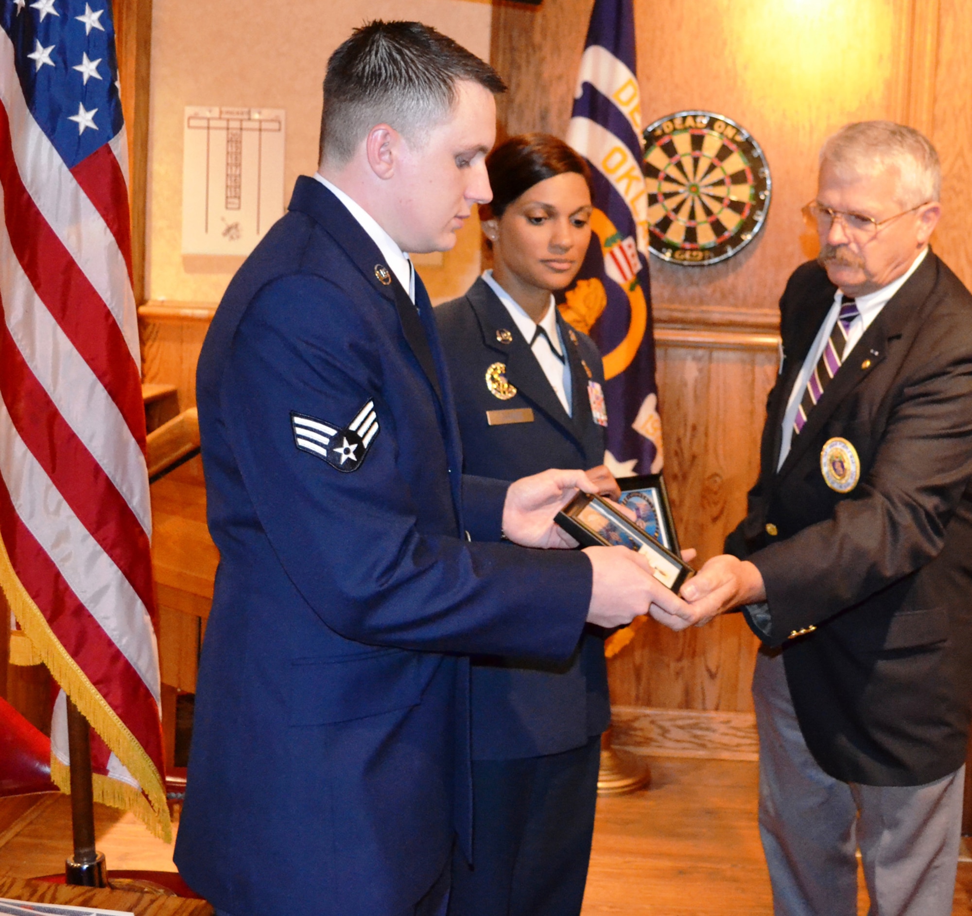 Charles Scott Jr. of the 568th Chapter of the Military Order of the Purple Heart presents induction certificates to Senior Airman Michael Helsdingen, 72nd Security Forces Squadron, and Senior Master Sgt. Melissa Garrett, 960th Airborne Air Control Squadron. They were two of five Team Tinker members honored by the chapter during the May 19 ceremony. (Air Force photo by Kathy E. Paine)