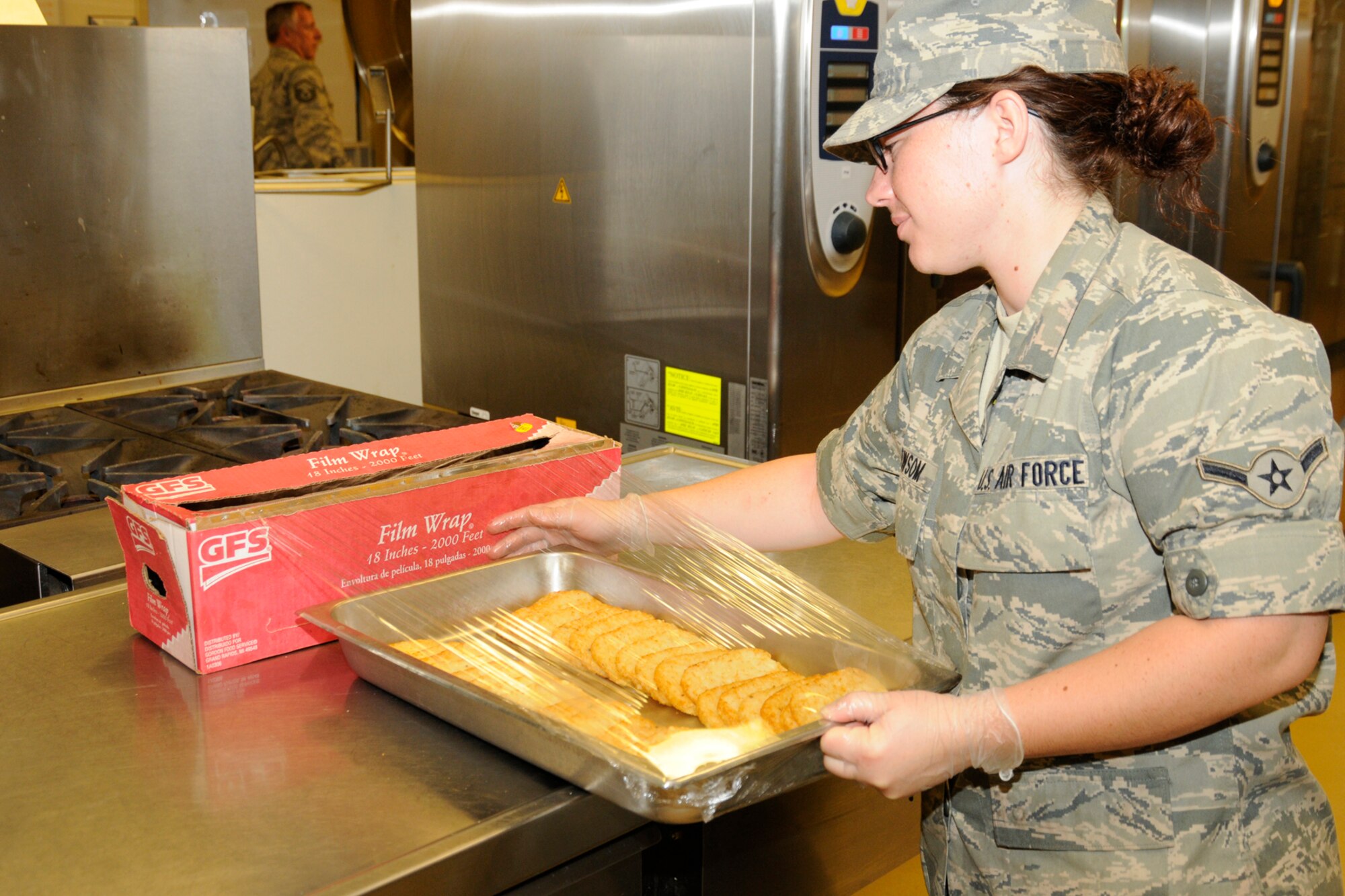 Airman Shelbi Newsom, 188th Fighter Wing, Arkansas Air National Guard, wraps a tray of hashed brown potatoes for breakfast service in the Thunder Bay Dining Facility at the Alpena Combat Readiness Training Center in Alpena, Mich., May 25, 2012. The Services personnel were supporting a medical disaster response training exercise at the CRTC. (U.S. Air Force photo by TSgt. David Kujawa)