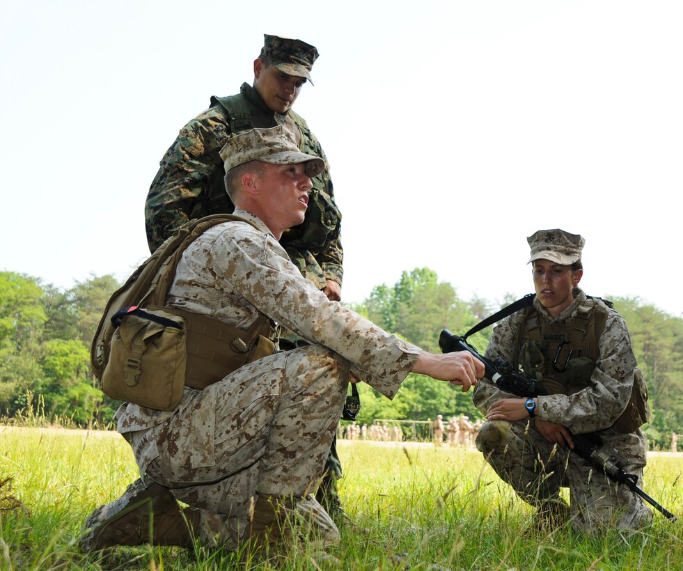 Second Lt. Jonathan Bowman, squad leader for 2nd Squad, 4th Platoon, Charlie Company, The Basic School, briefs his squad on the scheme of maneuver during a foot patrol exercise at Landing Zone 7, May 25. There to assess his mission brief is Sgt. Jose Zepata, a combat instructor, Dugout Platoon, Combat Instructor Company, TBS.