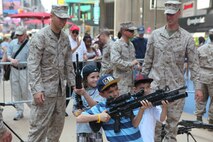 Children check out weapons during Marine Day in Times Square, May 26. Marine Day is part of Fleet Week New York 2012, where Marines and sailors show New Yorkers Marine Corps weapons, equipment and culture.