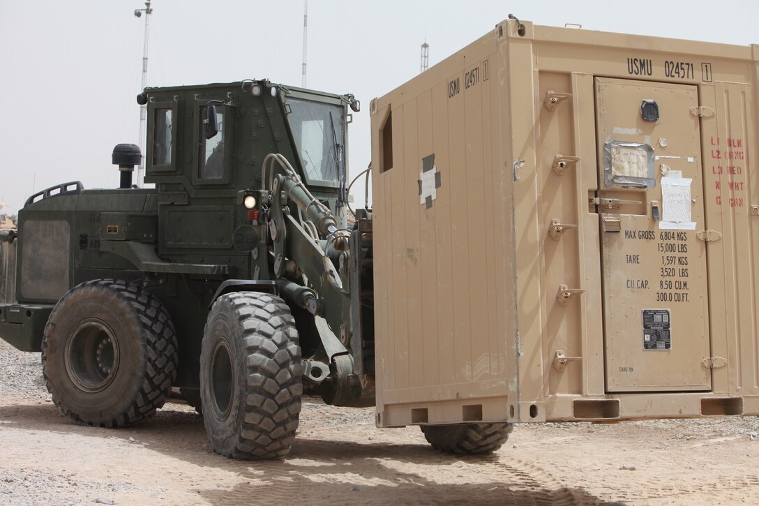 Lance Cpl. Othello Taylor, heavy equipment operator, Alpha Company, Combat Logistics Battalion 5, 1st Marine Logistics Group (Forward), moves a refrigeration unit using a Tractor, Rubber Tired, Articulated Steering, Multi-purpose vehicle at Forward Operating Base Hanson, May 25. As part of the retrograde efforts, CLB-5 removed a 20-foot refrigeration unit and replaced it with a smaller one.