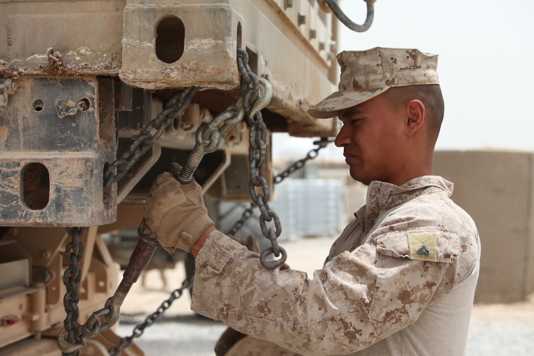 Cpl. Salvador Delatorre, line noncommissioned officer, 1st Platoon, Alpha Company, Combat Logistics Battalion 5, 1st Marine Logistics Group (Forward), chains down a refrigeration unit at Forward Operating Base Hanson, May 25. During the combat logistics patrol, 1st Plt. dropped off gear to FOBs Hanson, El Paso and Marjah and retrieved containers filled with gear the operating units no longer needed as part of the retrograde effort in Regional Command (Southwest).