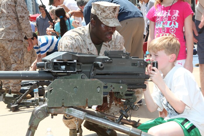 Lance Cpl. Mamadou Tamboura, and infantryman with 1st Battalion 9th Marines, shows New York children the Mark 19 grenade launcher during Marine Day in Times Square, May 26. Marine Day is part of Fleet Week New York 2012, where Marines and sailors show New Yorkers Marine Corps weapons, equipment and culture.