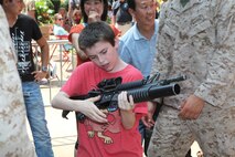 Jacob Lafidas, a civil air patrol cadet, handles an M203 grenade launcher for the first time during Marine Day in Times Square, May 26. Marine Day is part of Fleet Week New York 2012, where Marines and sailors show New Yorkers Marine Corps weapons, equipment and culture.