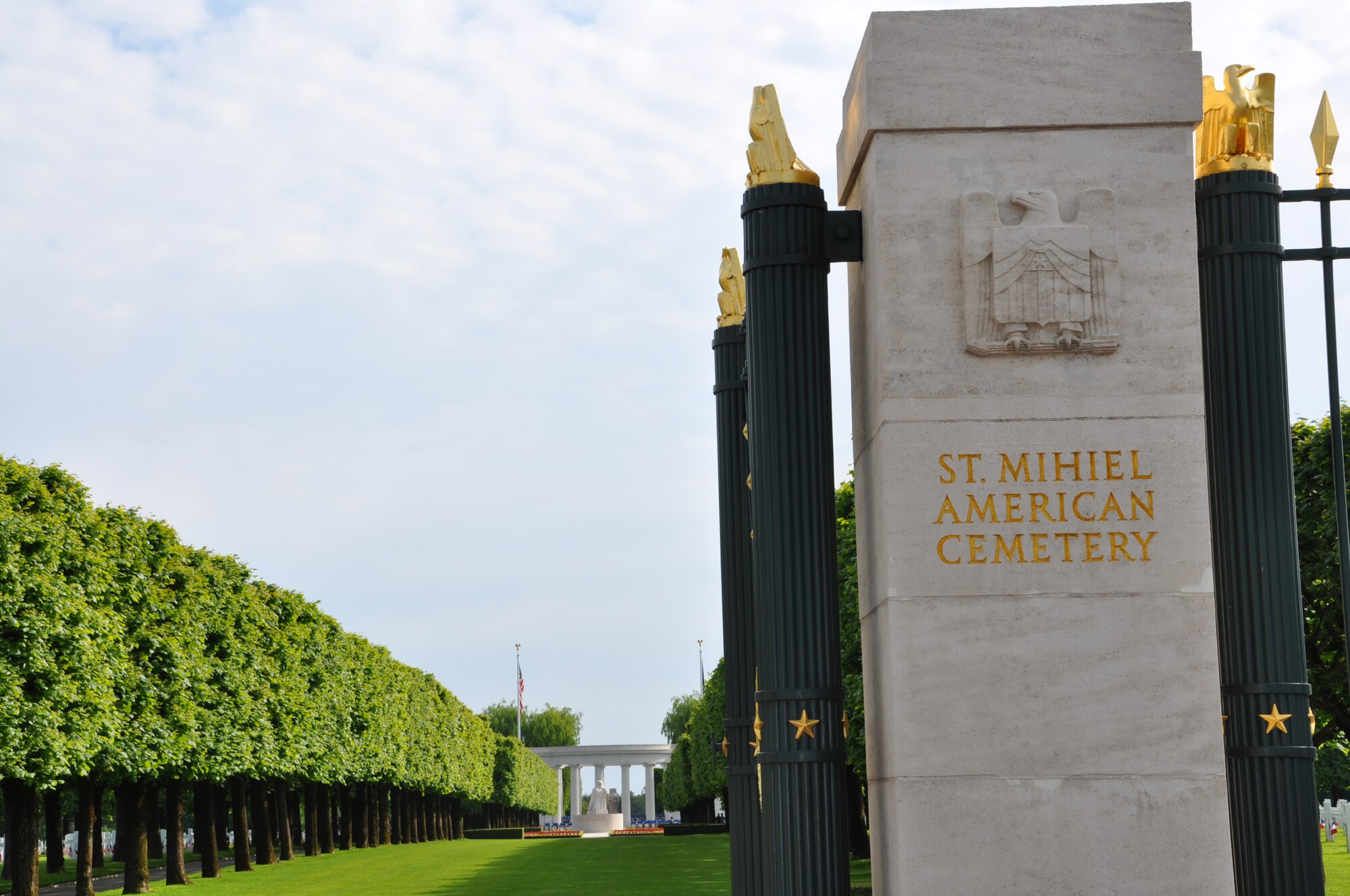 THIAUCOURT, France -- U.S. Air Forces in Europe Airmen participated in the annual Memorial Day events at the World War I St. Mihiel American Cemetery and Memorial here May 27, 2012. The 40.5-acres cemetery contains the graves of 4,153 of our military dead, according to the cemetery's website. The majority of these died in the offensive that resulted in the reduction of the St. Mihiel salient that threatened Paris. The burial area is divided by Linden alignment trees and paths into four equal plots. At the center is a large sundial surmounted by an American eagle. To the west is a statue of a World War I soldier and at the eastern end is a semi-circular overlook dominated by a sculpture representing a victory vase. Beyond the burial area to the south is the white stone memorial consisting of a small chapel, a peristyle with a large rose-granite funeral urn at its center, and a map building. The chapel contains a beautiful mosaic portraying an angel sheathing his sword. On two walls of the museum are recorded the names of 284 of the missing. Rosettes mark the names of those since recovered and identified. On the wall facing the door is a large map of inlaid marble depicting the St. Mihiel Offensive. The cemetery is open 9 a.m. to 5 p.m. daily, except Dec. 25 and Jan. 1. For more information, visit www.abmc.gov/cemeteries/cemeteries/sm.php.
