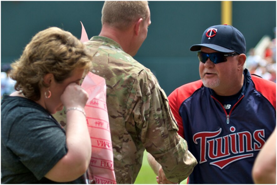 MINNEAPOLIS, Minn. - Master Sgt. Rob Buresh, an aeromedical evacuation technician with the 109th Aeromedical Evacuation Squadron of the 133rd Airlift Wing, is welcomed home by Minnesota Twins coach Ron Gardenhire after surprising his two girls Annie and Alex at Target Field here today.  (U.S. Air Force photo by Staff Sgt. Jonathan Young.)