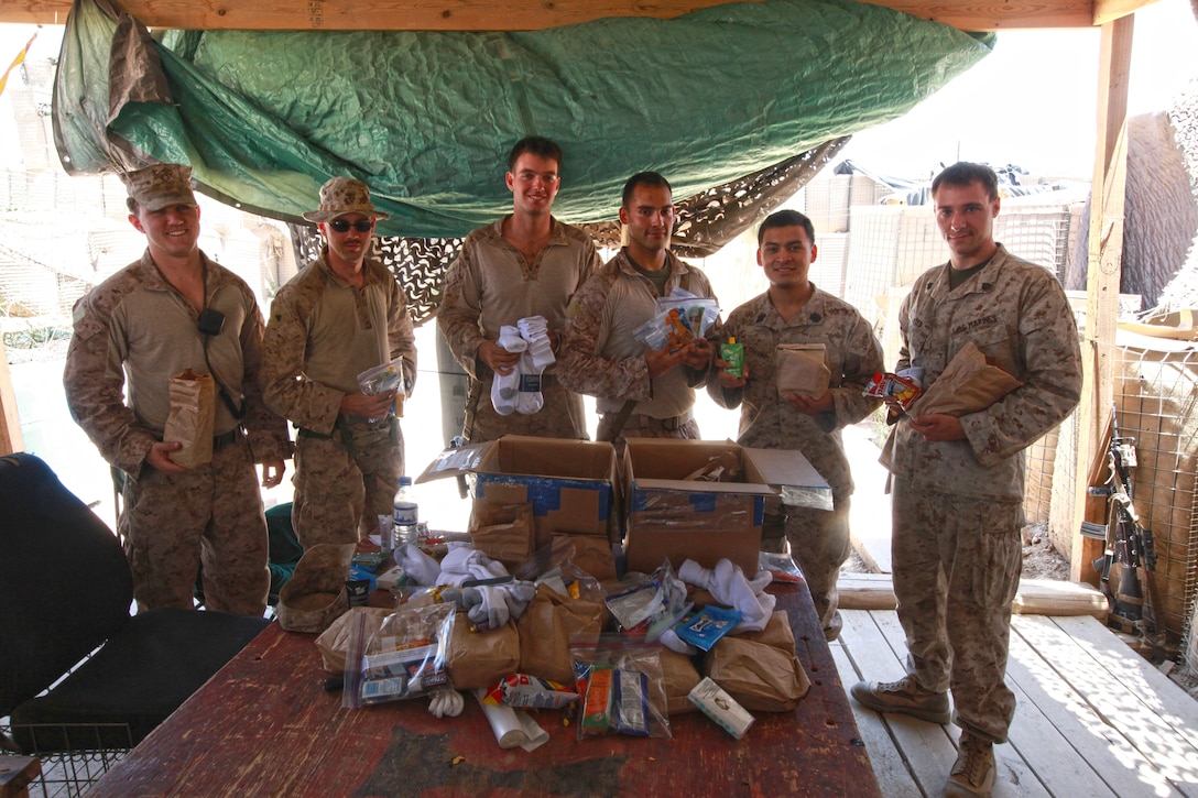 Marines with Police Advisory Team, 2nd Battalion, 5th Marine Regiment, receive care packages prepared by students at Sierra Academy of San Diego. The 3rd Marine Aircraft Wing (Forward) command chaplain delivered the packages to the Marines and sailors at Combat Outpost Now Zad, Afghanistan, May 27.