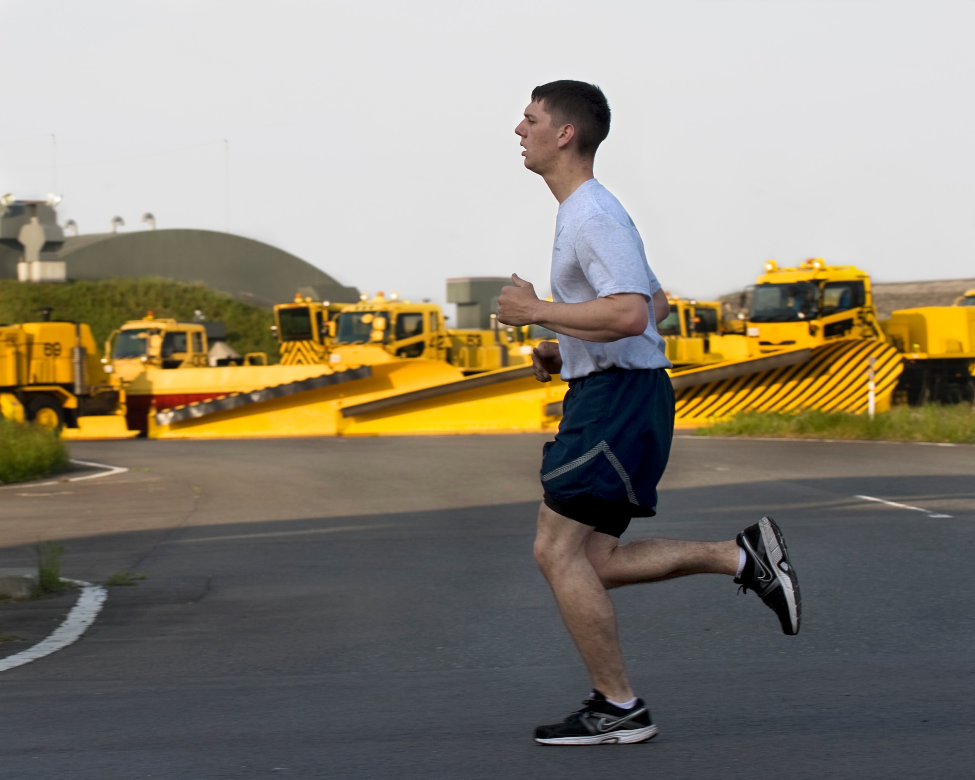 U.S. Air Force Airman 1st Class Chad Berry, 35th Logistics Readiness Squadron vehicle mechanic, runs past snow removal equipment, which he helps maintain, during the 35 LRS Memorial Day Run at Misawa Air Base, Japan, May 24, 2012. More than 100 runners participated in the run in tribute to those who had fallen in defense of their country. (U.S. Air Force photo by Staff Sgt. Nathan Lipscomb/Released)