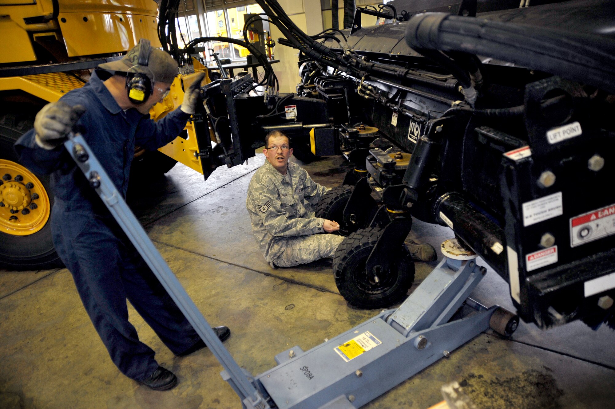 Shigeki Sumomozawa, 35th Logistics Readiness Squadron vehicle mechanic, left and Staff Sgt. Robert Reich, 35th Logistics Readiness Squadron vehicle maintenance journeyman, replace the tires on a power snow broom at Misawa Air Base, Japan, May 23, 2012. More than 70 pieces of snow removal equipment are maintained by the Vehicle Management Flight. (U.S. Air Force photo by Staff Sgt. Nathan Lipscomb/Released)