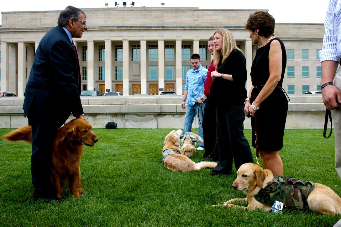 Defense Secretary Leon E. Panetta and his dog, Bravo, speak with Sara Hook, director of the Warrior Transition Brigade Service Dog Training Program, center, at the Pentagon, May 23, 2012. 