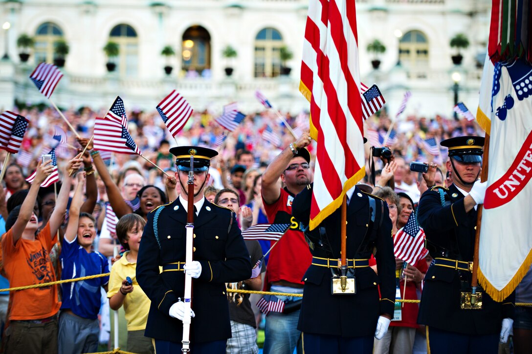 Audience members wave American flags during the National Memorial Day concert at the National Mall in Washington, D.C., May 27, 2012.