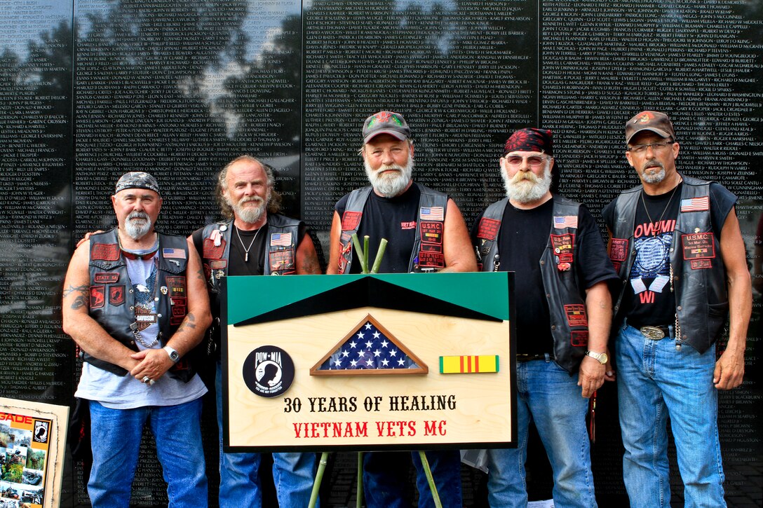 A group of Vietnam War veterans from Wisconsin stands with their sign at the Vietnam Veterans Memorial in Washington, D.C., May 28, 2012, after a Memorial Day event commemorating the 50th anniversary of the war.