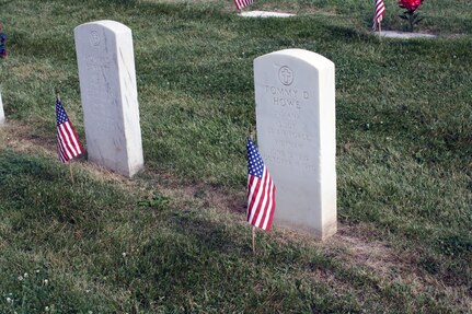 OFFUTT AIR FORCE BASE, Neb. - Headstones at the Offutt AFB cemetery are decorated with flags prior to the start of a Memorial Day ceremony May 28, 2012.  Every year the grave of fallen servicemembers are adorned with flags to honor their service and sacrifice.