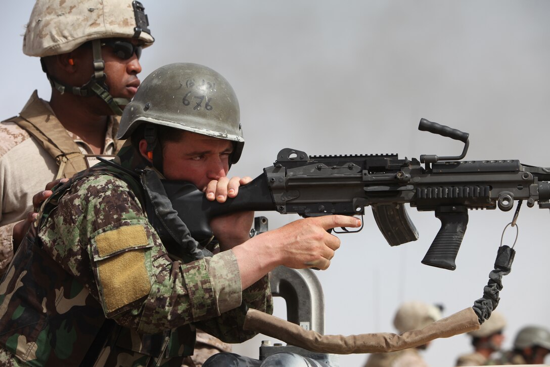 Sgt. James Eugene, an advisor with the Combat Logistics Battalion 5 Embedded Partnering Team, watches the firing area during a live fire with the Afghan National Army at Camp Dwyer, Afghanistan, May 29. As part of the EPT, the Marines advise counterparts with the 5th Kandak, 1st Brigade.