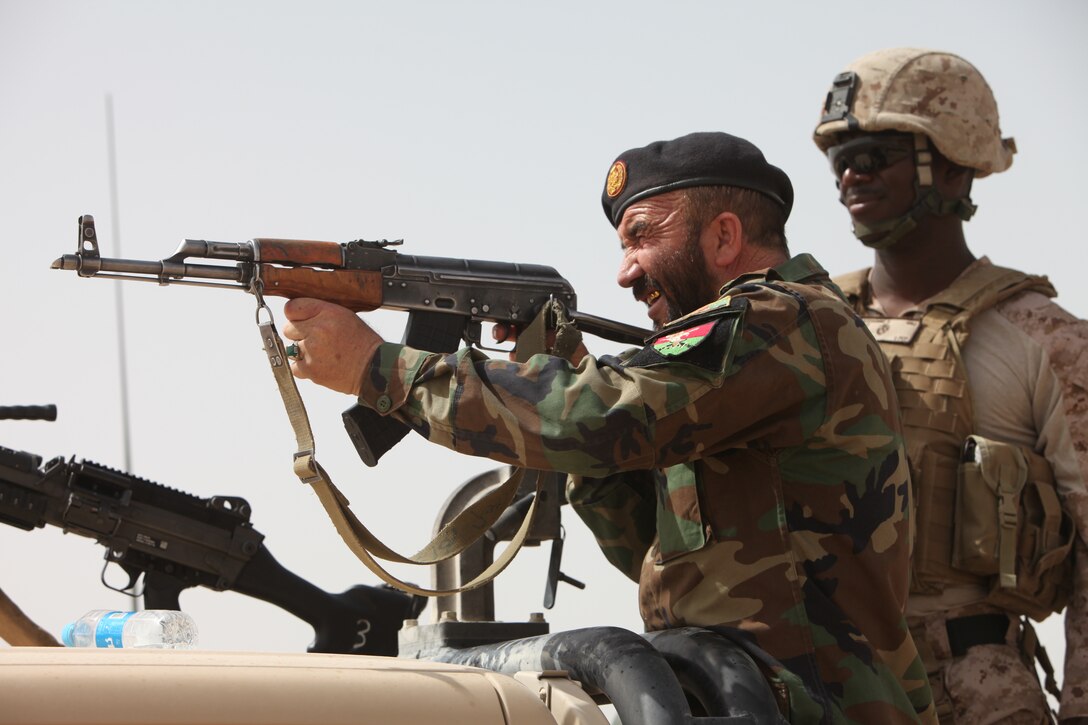 Lt. Col. Amanullah Khobani, commander of the 5th Kandak, 1st Brigade, Afghan National Army, fires his automatic weapon during a live-fire range with the Combat Logistics Battalion 5 Embedded Partnering Team at Camp Dwyer, Afghanistan, May 29. During the range, Marine advisers with the EPT assisted the ANA improving their accuracy with their weapons.