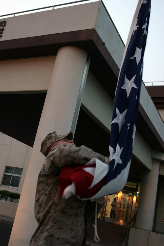 Lance Cpl. Whitford L. Horton, station Aircraft Rescue Fightfighter, wraps up the National Colors while performing the flag lowering ceremony at sunset here May 29, 2012. National Colors here in front of Building one are raised and lowered every morning and every evening to show our respect for the Americans who have served and for all the freedoms America holds true.