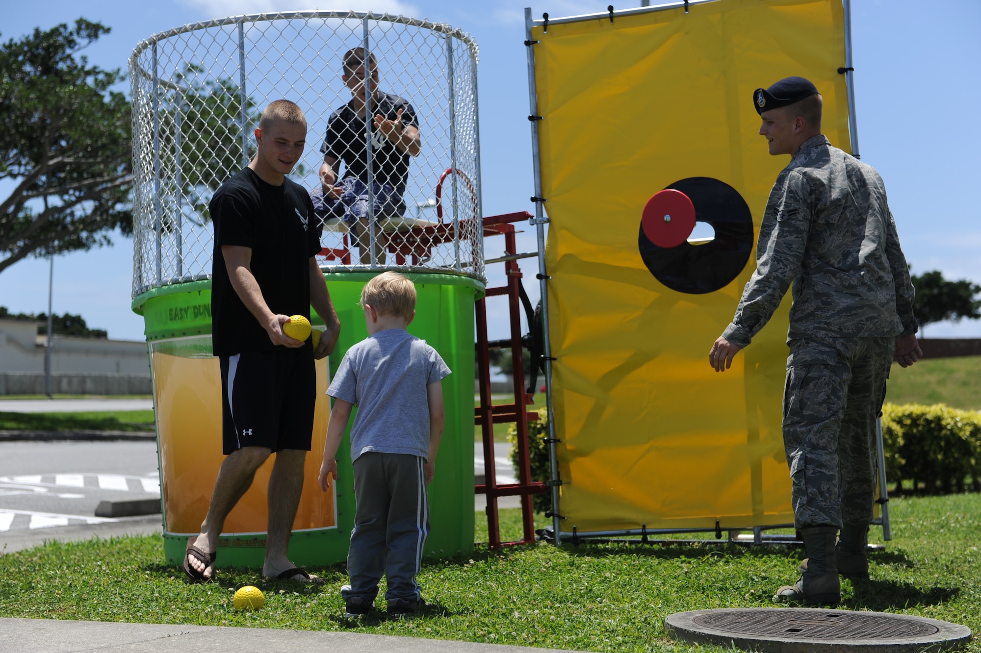 An 18th Security Forces Squadron member hands a ball to a child for the dunk tank at the unit's open house on Kadena Air Base, Japan, May 23, 2012. The unit opened its doors to the community as part of National Police Week activities. (U.S Air Force photo/Airman 1st Class Malia Jenkins)  