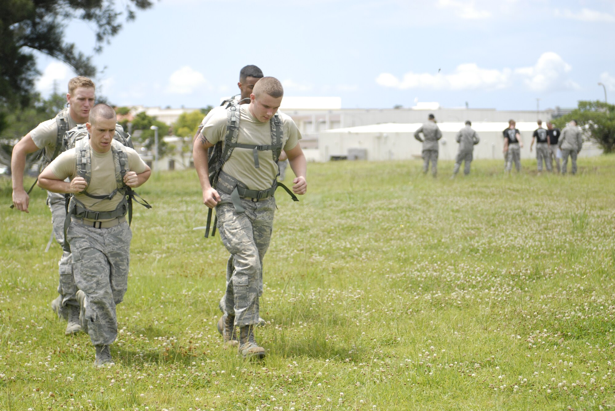 (back left) Airman 1st Class Joshua Sutton (front left) Airman 1st Class Brandon Spears (back right) Airman 1st Class Rashawn Richards (front right) Airman 1st Class Kenneth Stuart of Team Charlie march a mile and a half from the 18th Security Forces Squadron to their next event during National Police Week on Kadena Air Base, Japan, May 22, 2012. The march was another test for the teams to tap into their deployment training. (U.S Air Force photo/Airman 1st Class Malia Jenkins)  