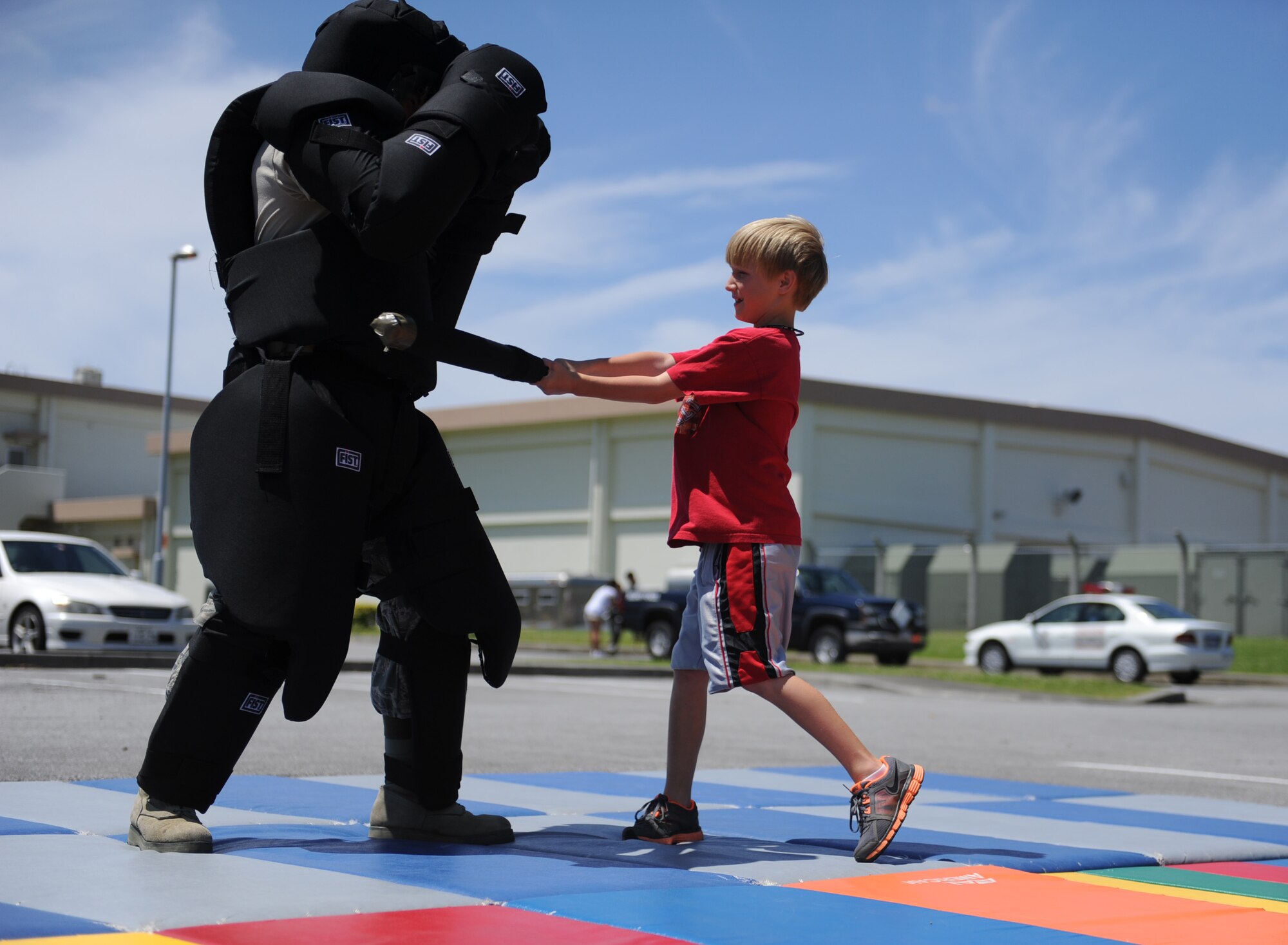 An 18th Security Forces Squadron Airman takes a beating guests attending the unit's National Police Week open house on Kadena Air Base, Japan, May 23, 2012. The unit showcased equipment such as the "RedMan suit" that is used for baton training. (U.S Air Force photo/Airman 1st Class Malia Jenkins)  