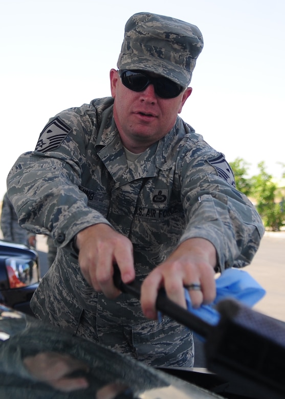 Master Sgt. Jason Twing, 9th 9th Aircraft Maintenance Squadron first sergeant, washes a windshield of a retired Airman May 24, 2012 at the housing shoppette, Beale Air Force Base, Calif. The first sergeants gave away $2,000 in fuel to Airmen E-1 through E-5 for Operation Warm Heart as random acts of kindness, but washed the windshield of each vehicle that stopped at the pumps. (U.S. Air Force photo by Senior Airman Shawn Nickel)