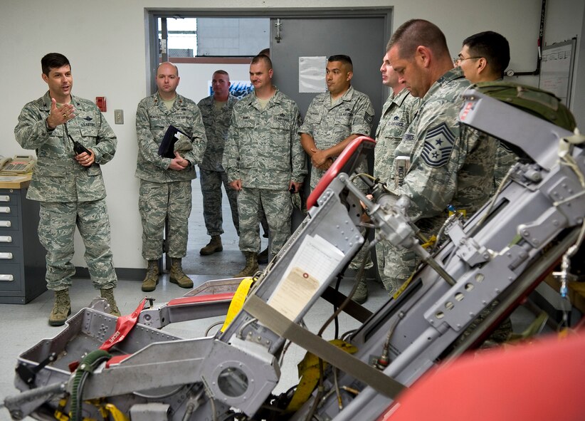 Col. Andrew Gebara, 2nd Bomb Wing commander, speaks to Airmen in the egress shop during a tour of the 2nd Maintenance Squadron facilities on Barksdale Air Force Base, La., May 29. The egress shop maintains the ejection seats the aircrew uses to exit the aircraft in case of an emergency. (U.S. Air Force photo/Staff Sgt. Chad Warren)(RELEASED)