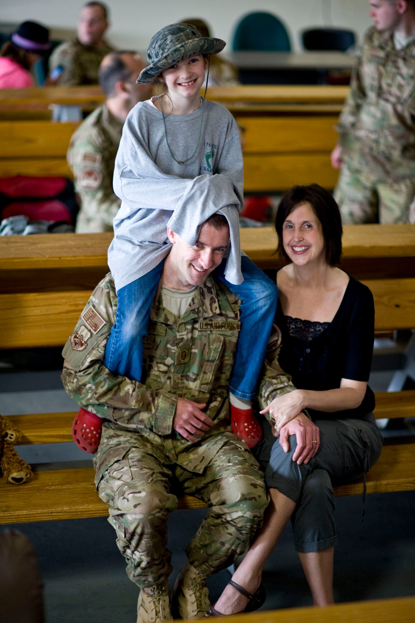 JOINT BASE ELMENDORF-RICHARDSON, Alaska - Master Sgt. Dennis Mobley, a helicopter crew chief with the Alaska Air National Guard's 176th Aircraft Maintenance Squadron, spends some quality time with his daughter Kailee and his wife, Heidi, while waiting to depart Alaska for Afghanistan May 28, 2012. More than 180 members of the Alaska Air National Guard's 176th Wing are deploying for about 120 days in support of Operation Enduring Freedom. (National Guard photo by Master Sgt. Shannon Oleson)