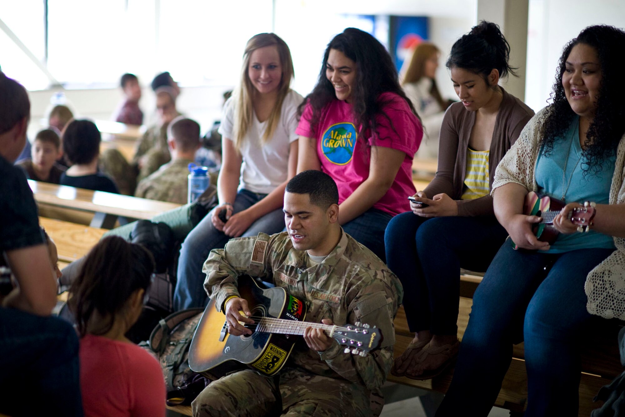 JOINT BASE ELMENDORF-RICHARDSON, Alaska - Senior Airman Donald Haretuku, an aircrew flight equipment specialist for the Alaska Air National Guard's 176th Operations Support Squadron, plays the guitar and sings with family and friends while waiting to depart Alaska for Afghanistan May 28, 2012. More than 180 members of the Alaska Air National Guard's 176th Wing are deploying for about 120 days in support of Operation Enduring Freedom. (National Guard photo by Master Sgt. Shannon Oleson)