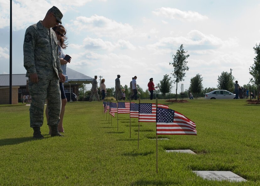 Senior Master Sgt. Chris Hartman, 7th Equipment Maintenance Squadron, walks the cemetery grounds placing American flags on the headstones of fallen veterans May 27, 2012, at the Texas State Veterans Cemetery in Abilene, Texas. Memorial Day is a day of remembering the men and women who died while serving in the United States Armed Forces. Formerly known as Decoration Day, it originated after the American Civil War to commemorate the Union soldiers who died in the Civil War. By the 20th century Memorial Day had been extended to honor all Americans who have died in all wars. (U.S. Air Force photo by Airman 1st Class Peter Thompson/ Released)